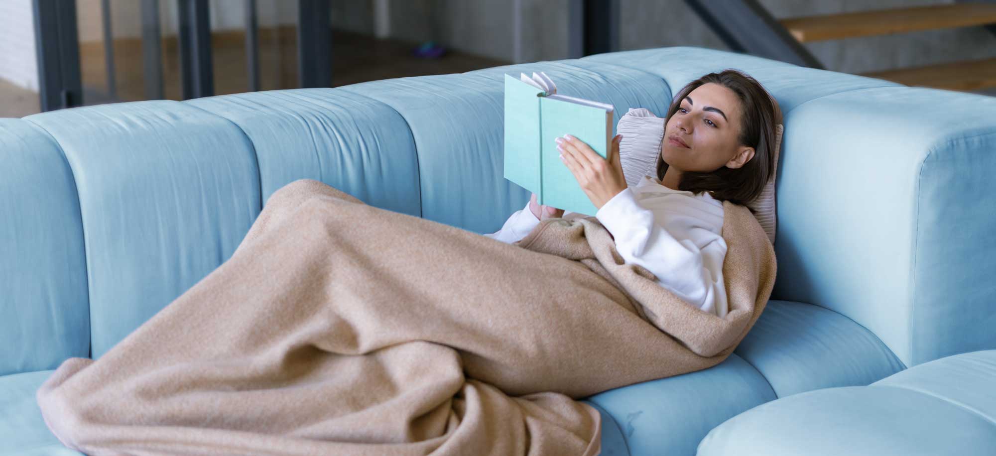 Middle age lady reading how to use instructions for Cool Embrace, Laying underneath the Menopause blanket